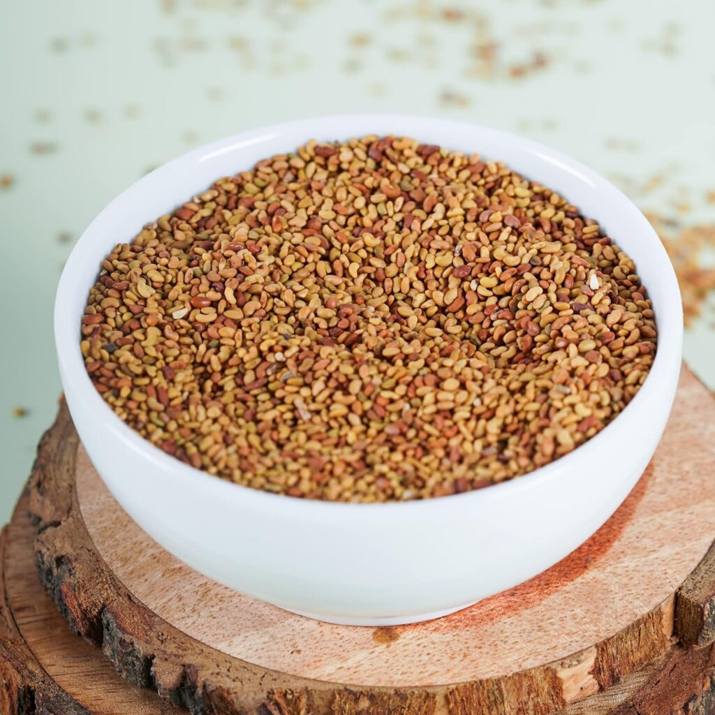 A close-up image of alfalfa seeds, showing their small, oval shape and earthy green color.